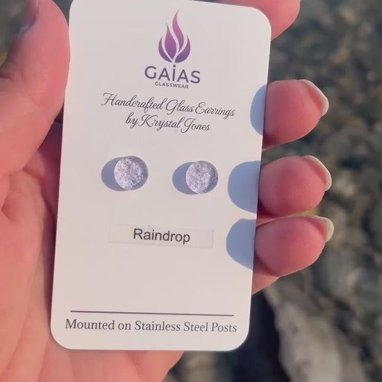 Handmade Raindrop fused glass stud earrings featuring water-inspired blue tones and stainless steel posts, crafted by Canadian glass artist Krystal Jones.