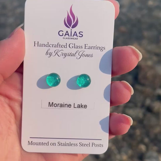 Handmade Moraine Lake fused glass stud earrings inspired by the turquoise waters of the Canadian Rockies, featuring blue and green tones with stainless steel posts, crafted by Canadian glass artist Krystal Jones.