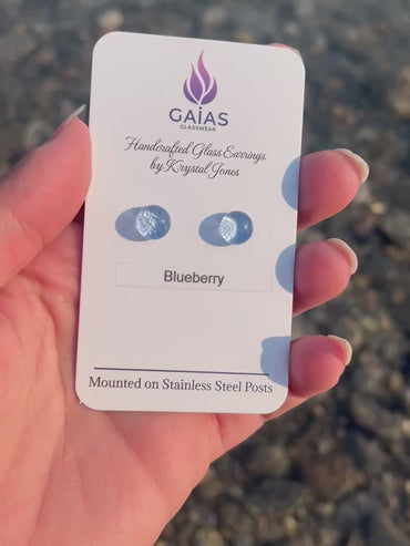 Handmade blueberry-inspired fused glass stud earrings with blue glass berries and stainless steel posts, crafted by Canadian glass artist Krystal Jones.