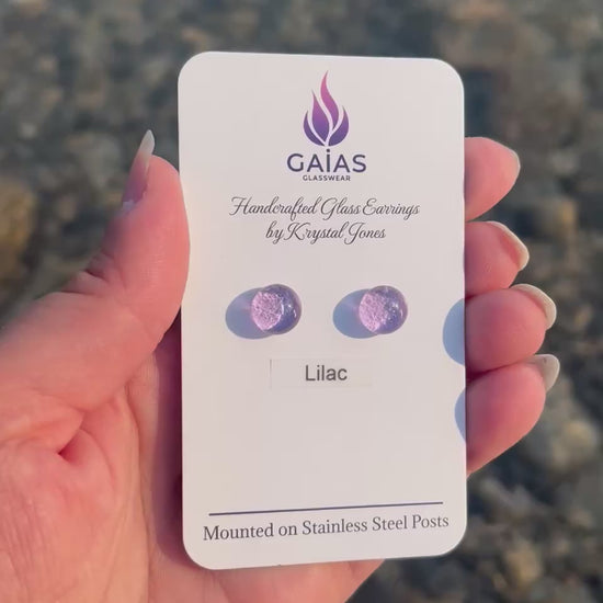 Handmade Lilac fused glass stud earrings featuring soft purple tones and stainless steel posts, crafted by Canadian glass artist Krystal Jones.